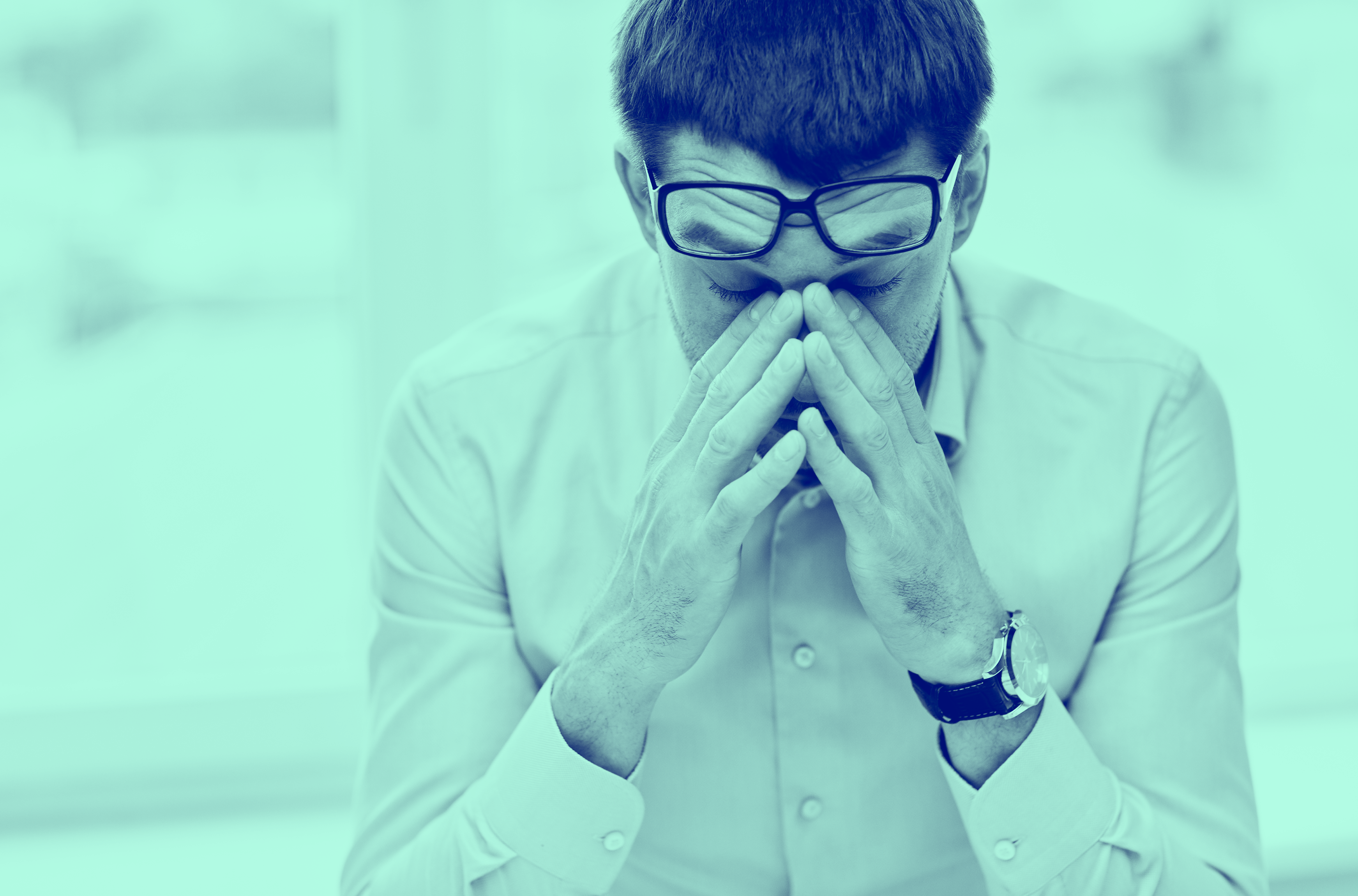 Blue washed image of man with head in his hands