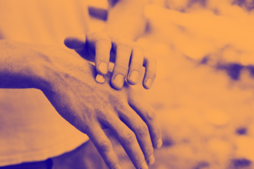 orange washed image of cream being applied to hand